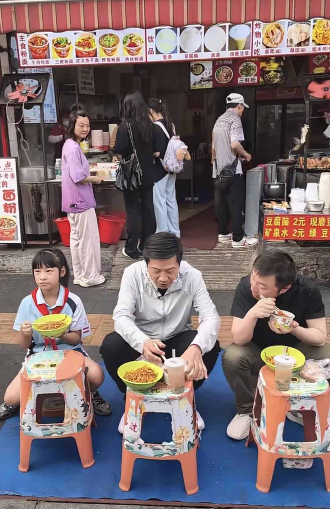 小米董事长雷军武汉大成路街头过早，一碗热干面放门口凳子上，边吃边擤鼻涕，吃