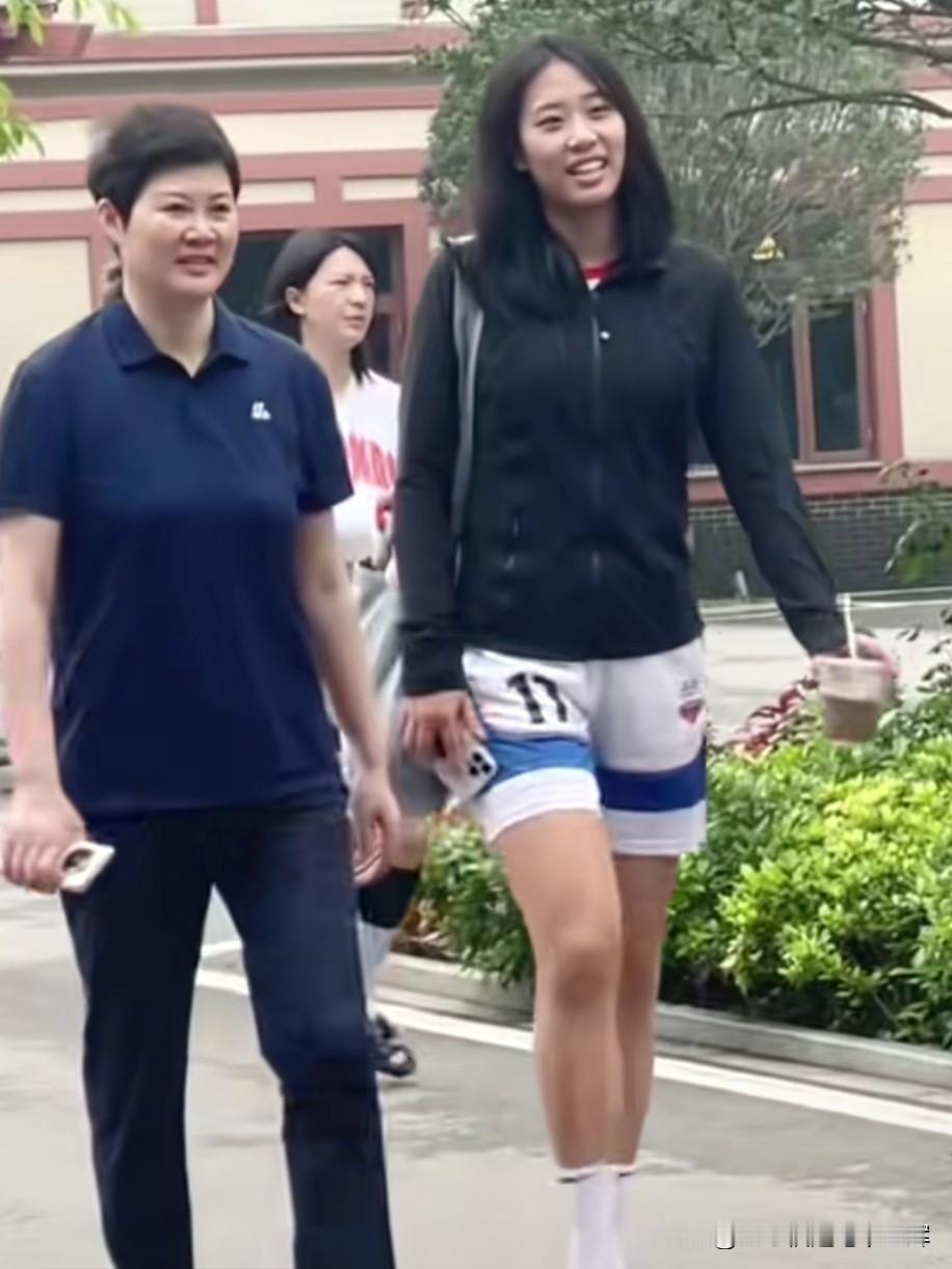 唐子婷身旁，是她的大学恩师李笋南，北师大女篮主教练。两人并肩同行、轻声交谈，眉