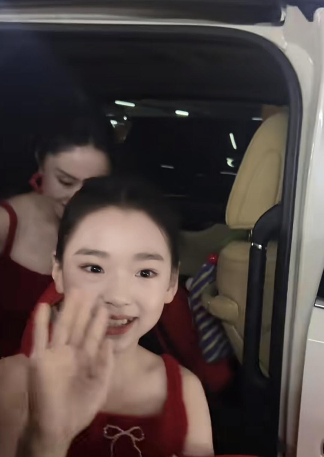 小酒窝与董璇从车上下来，母女俩都穿大红色吊带裙子，扎同款高马尾，准备一起参