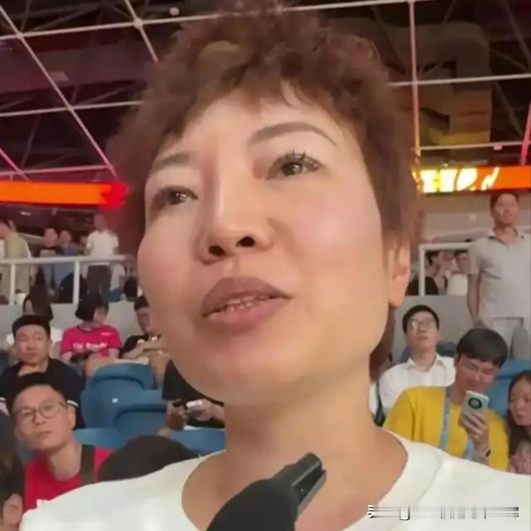廖三宁的母亲端庄大气，和儿子眉眼极为相像。赛场边她默默守候，专注观赛，递毛