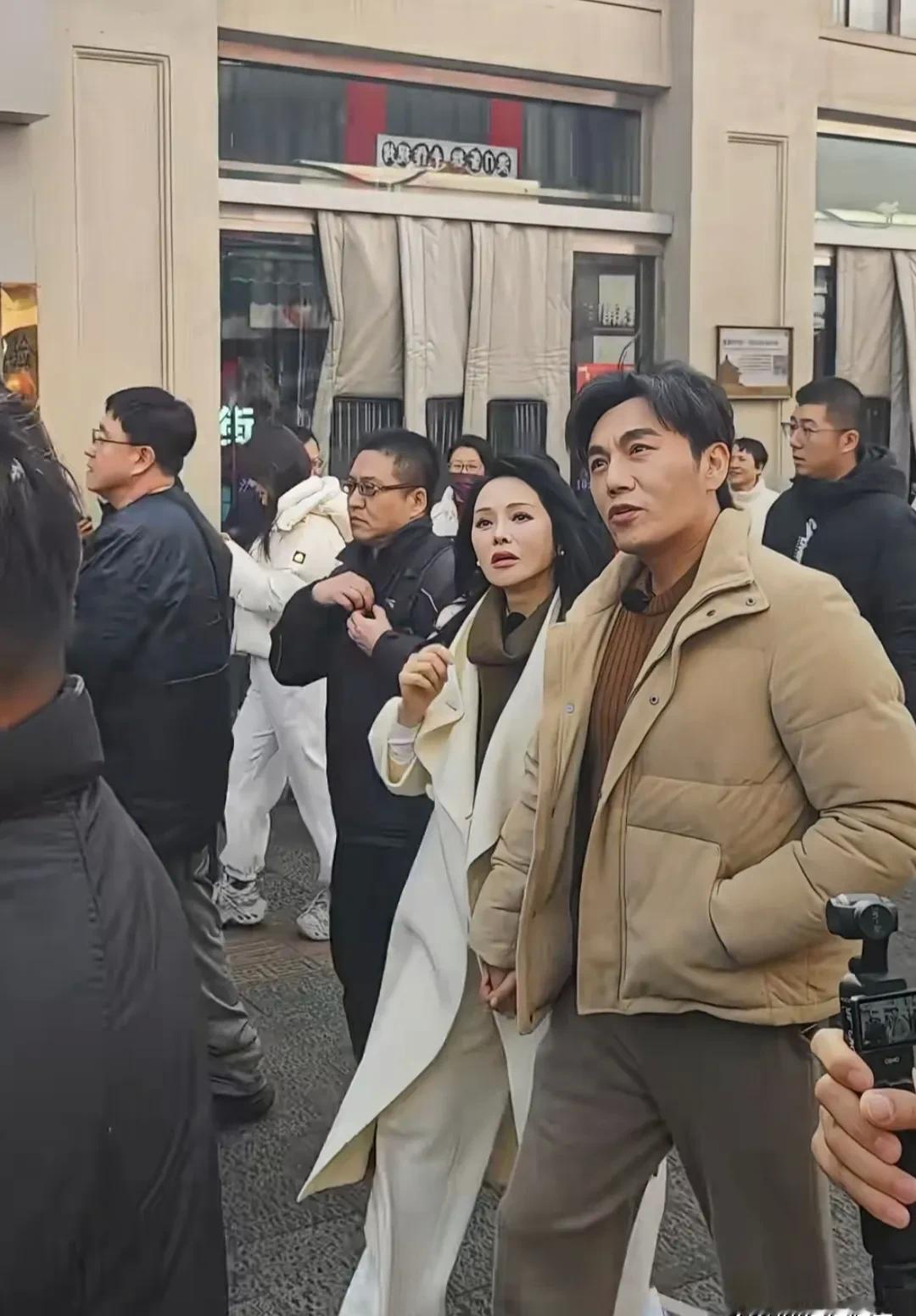56岁的伊能静牵着秦昊的手走在沈阳街头，她脸上连一丝皱纹都找不到，路人的下巴全掉