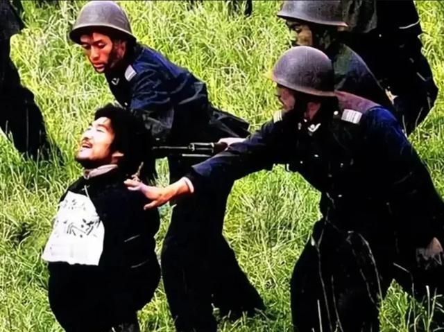 1990年，枪决西北悍匪魏振海的现场，照片中魏振海被五花大绑地跪在草丛中，一把上
