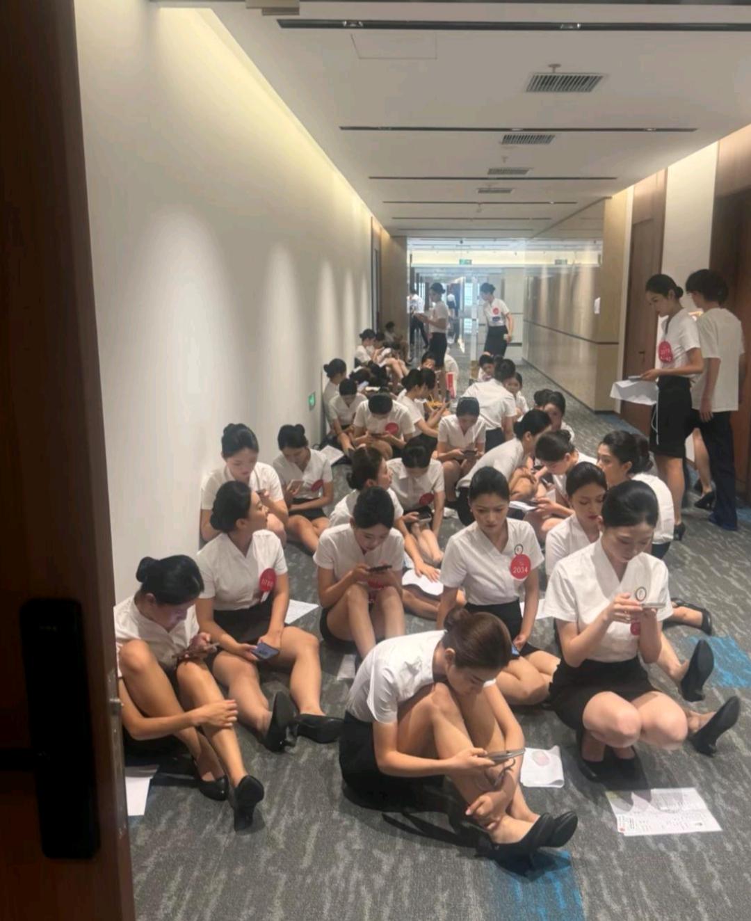 等待面试的空姐们，招聘单位也不准备一些凳子，就这么席地而坐！[无奈吐舌]