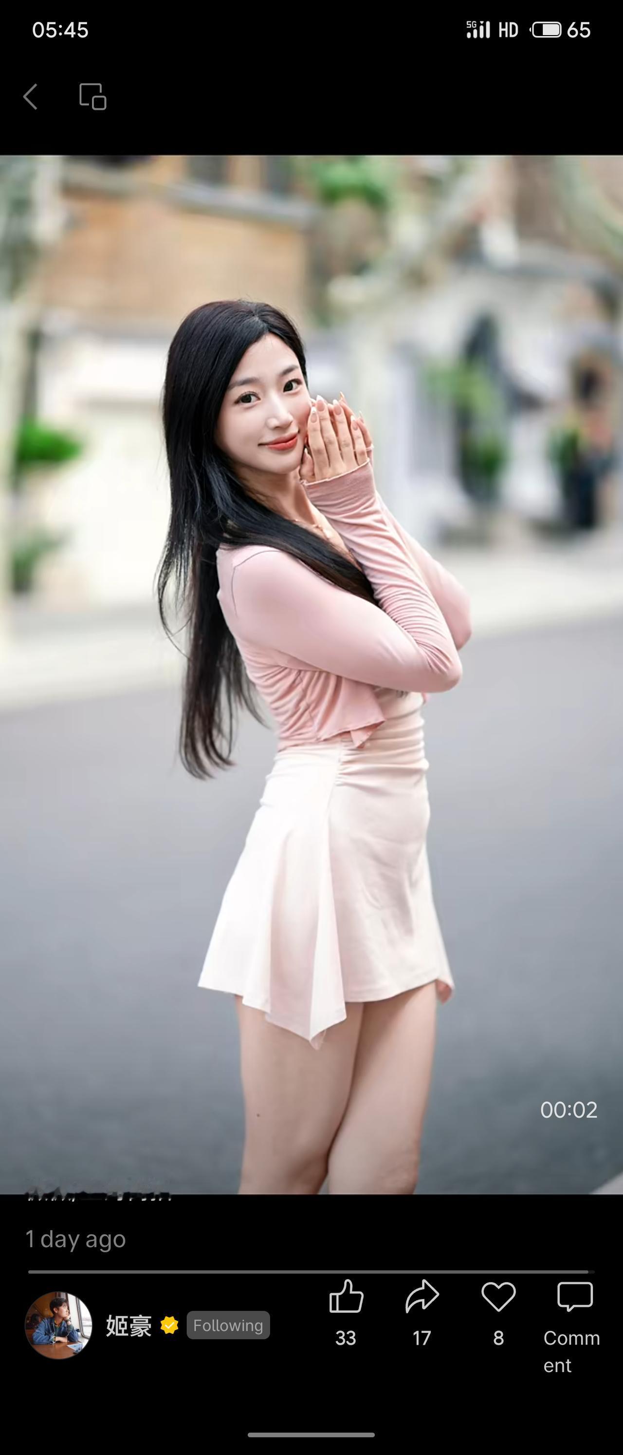 老上海梧桐街道街边，长发女孩一身浅粉开衫搭配米白吊带短裙。笑容清甜柔软，身形窈窕