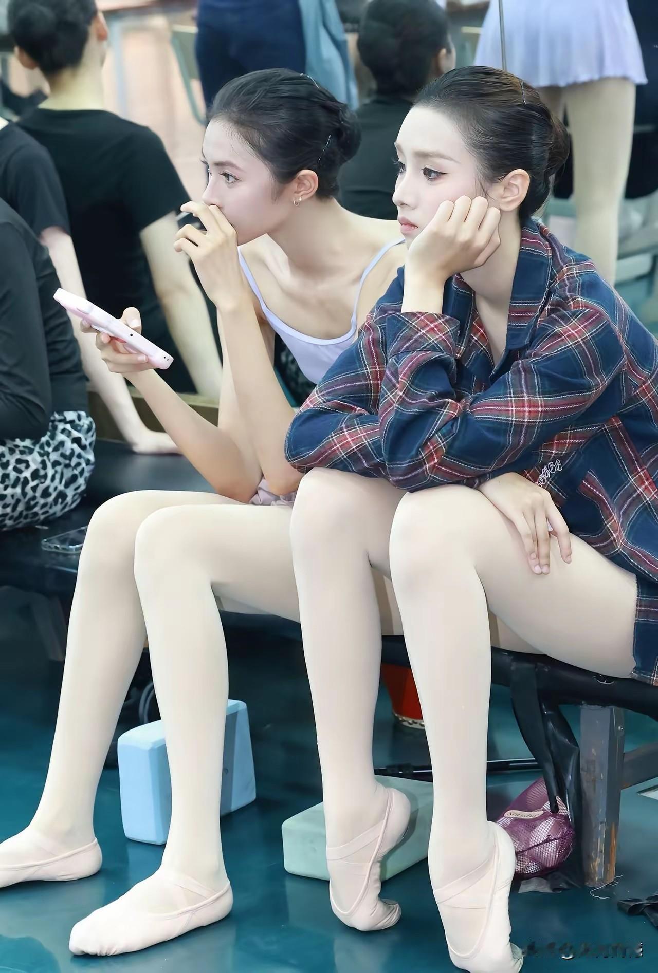 这两个女孩看起来像是一对双胞胎，脸型长得都非常像，发型也一样，身材也非常像，而且