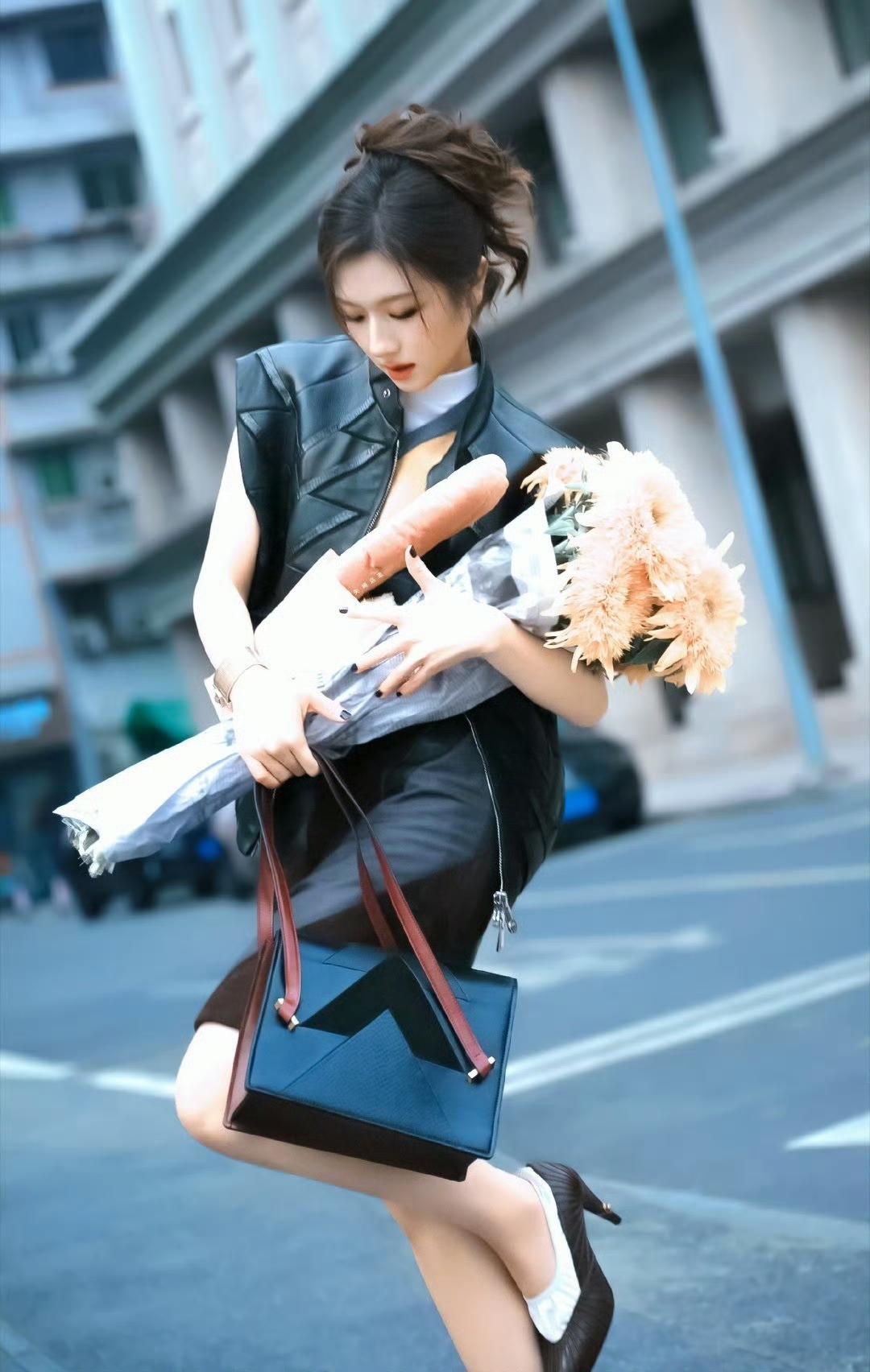 都市时尚少女，手捧鲜花，优雅漫步在街头。李兰迪！！！