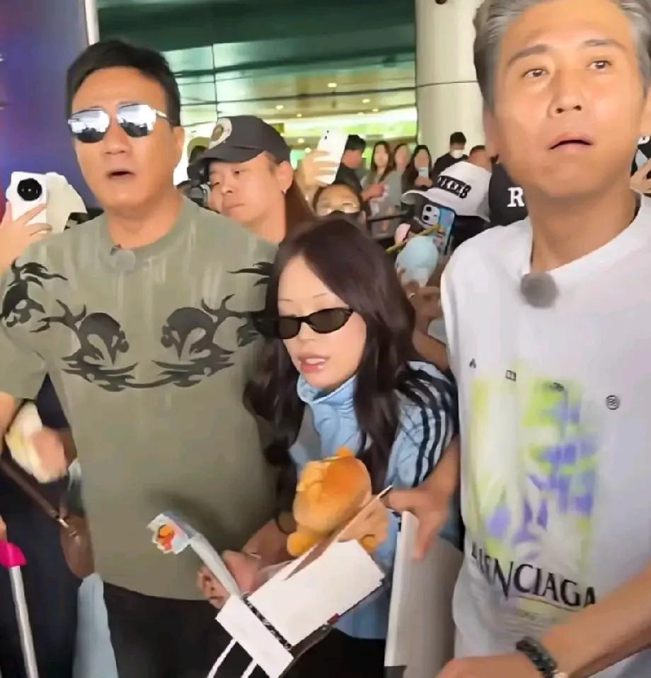 大连周水子机场，胡军和李乃文一左一右，把万妮达夹在中间往前走。两个身高一米八上下的中年男人，表情严肃