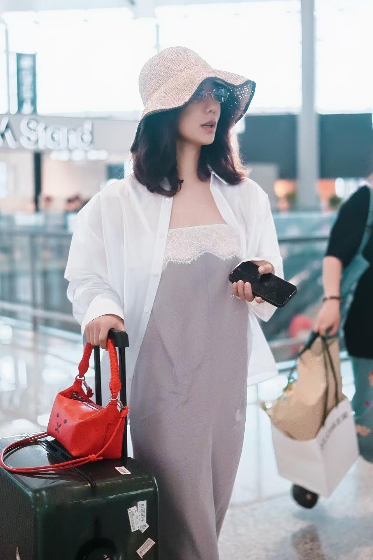 王珞丹度假风街拍，这一身很松弛！浅灰蕾丝吊带长裙，外搭一件宽松透感白衬衫，随性