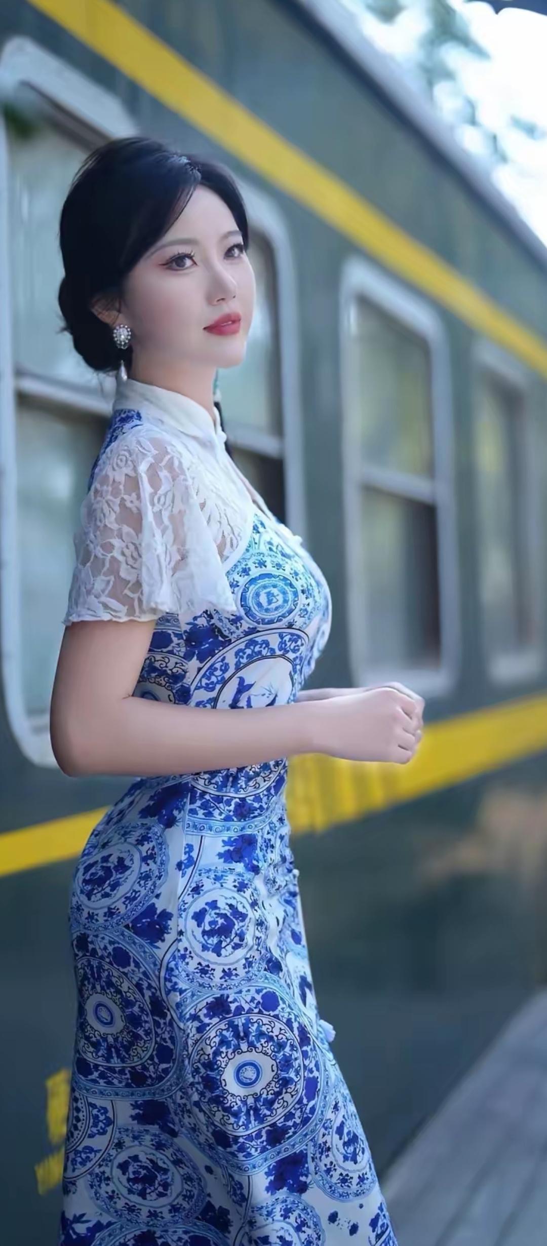 蓝衣美人倚绿车，风姿绰约似画卷。