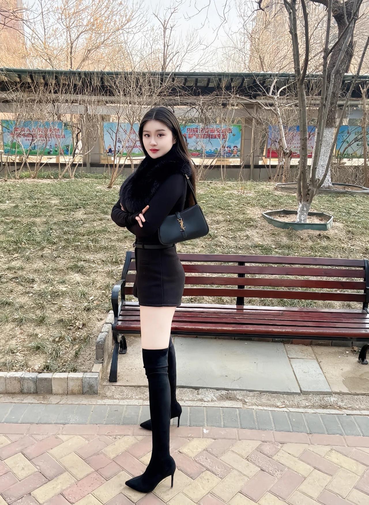 冬日暖阳下，黑衣少女静坐长椅，享受宁静时光。