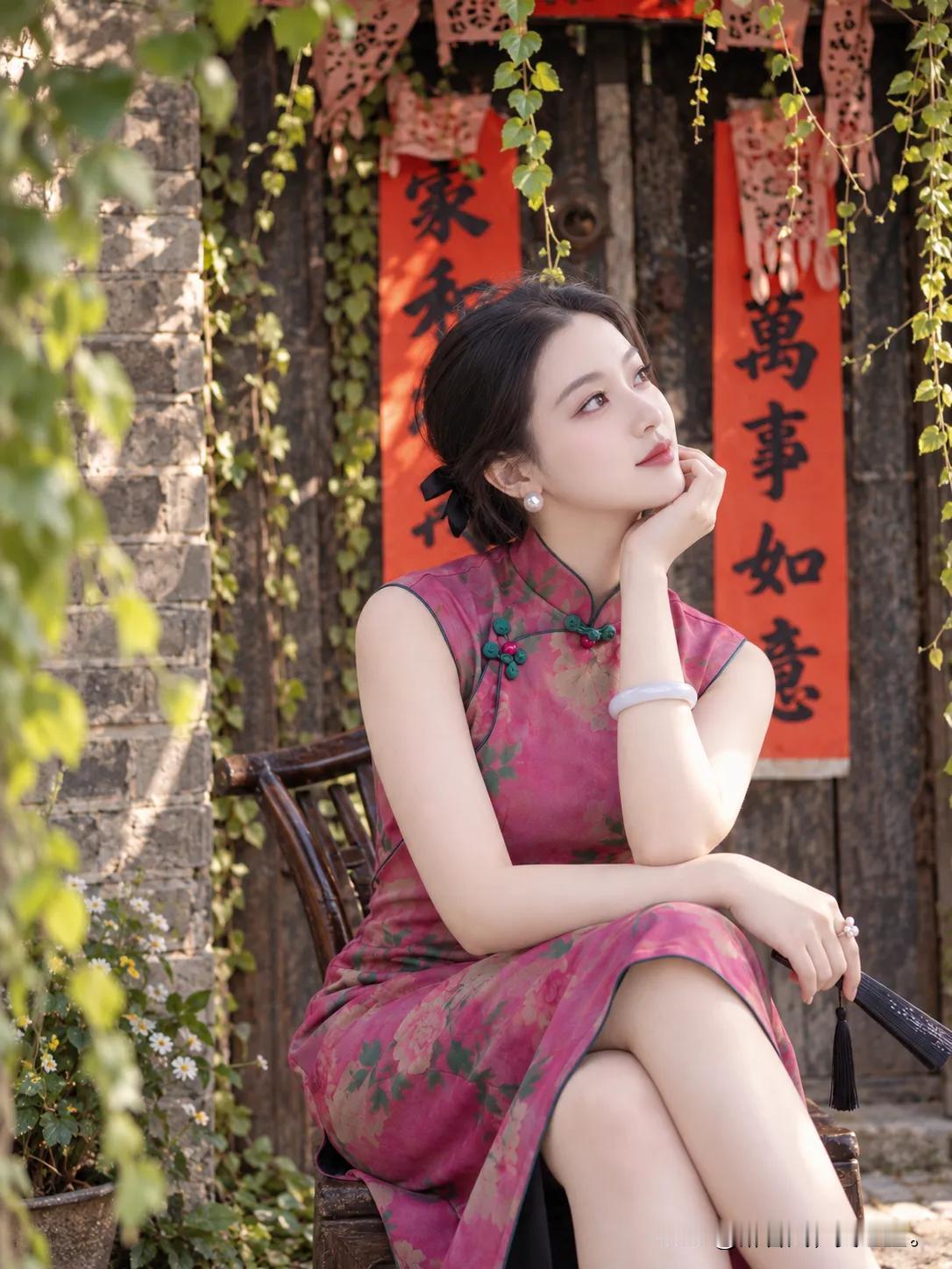 粉色旗袍小姐姐倚门而坐，背景“家和万事”太应景啦！阳光正好，这氛围感简直绝绝子～