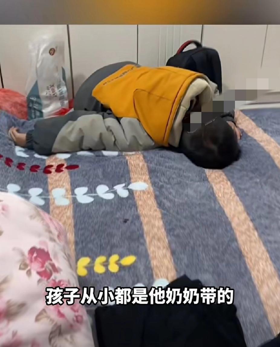 11月26日，河南南阳。奶奶去世，小孙子不哭不闹，静静地抱着奶奶的衣服，趴在奶奶