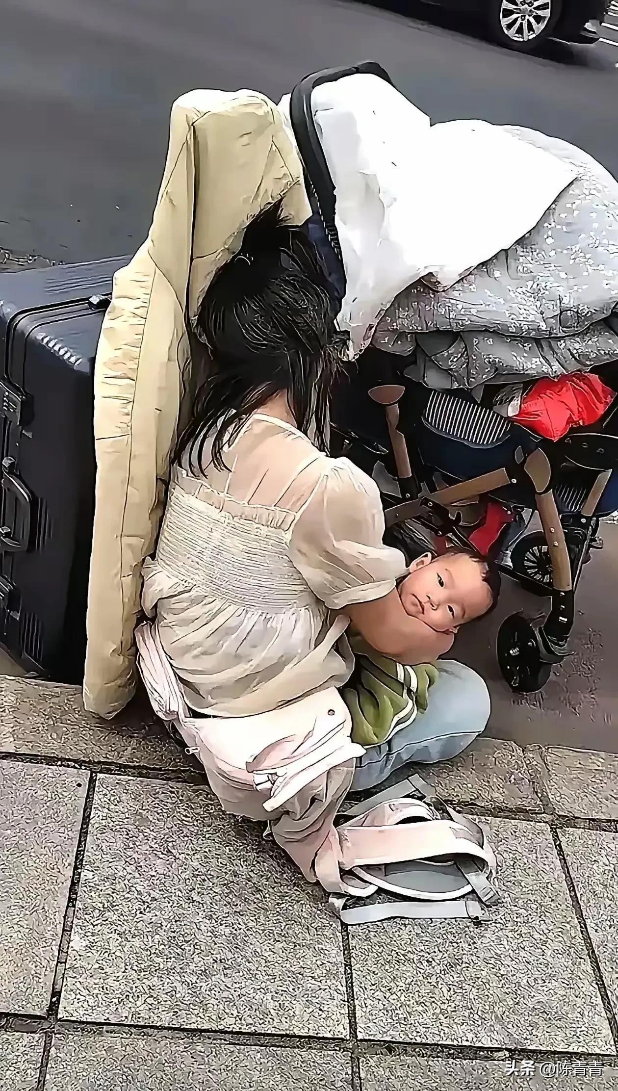 这小媳妇抱着小孩蹲在马路沿子上，她的头发很凌乱的，这是遇到难题了？看这架势像