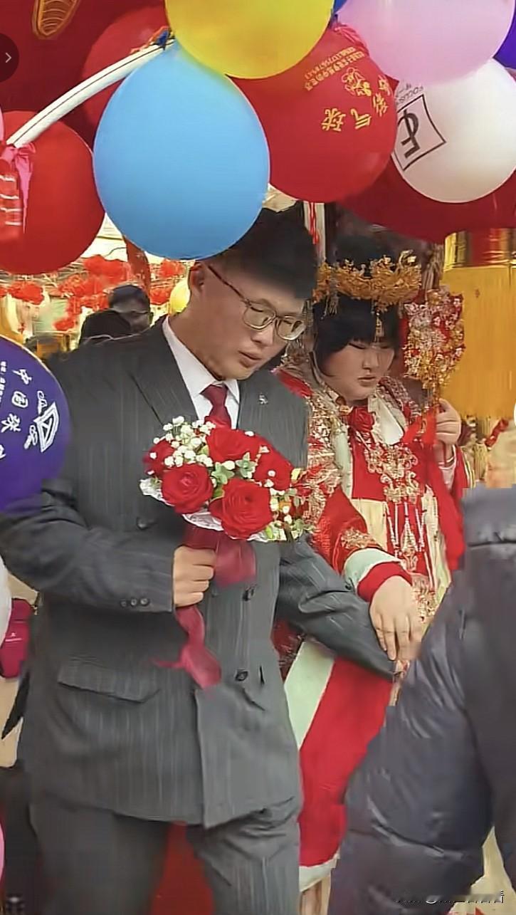 朱之文女儿朱雪梅今天结婚了，新郎托着新娘的手，新娘凤冠霞披穿在身上，新郎西服领带