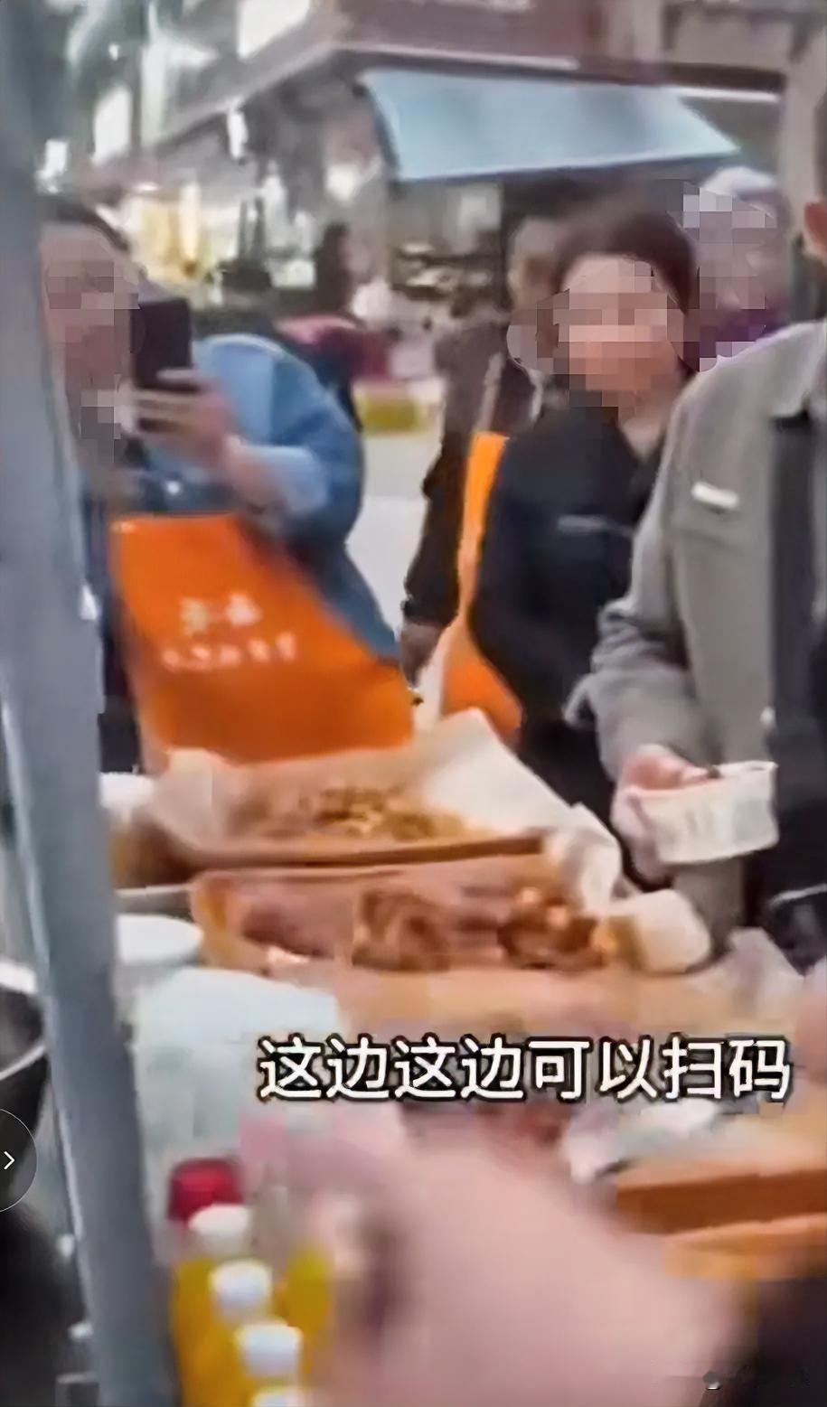 好不好吃，好吃麻烦你扫一下码，不好意思，今天没带钱。一大妈在街边品尝小吃摊位