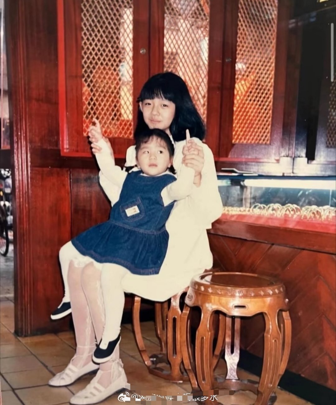 大S坐在自家银楼里，神情像个小大人，从她身上的鞋子袜子便能看出她从小就活得精致​