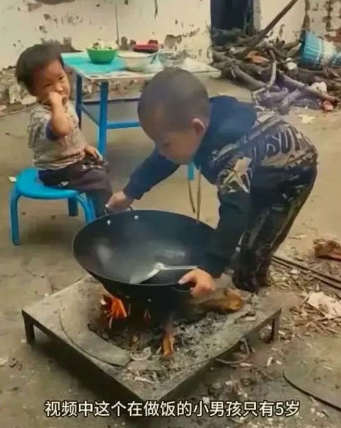 太可怜了！为什么世间这么多的疾苦！这个正在做饭的小男孩才5岁，而旁边坐着的小孩是