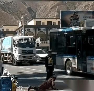 马路就这么宽。一边，是匍匐在地的身体，丈量着去往圣地的距离。另一边，是笔直挺