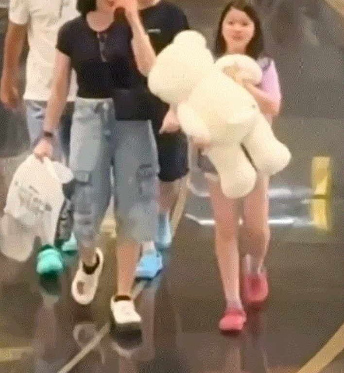 小女孩一家四口在商场内闲逛，期间一名男子则抱着几只大熊玩偶从一家子身边经过。不料