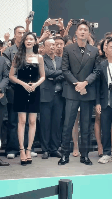 哈哈哈，张天爱双手交叉于腹前，和自己右侧的人挨得很近；林也是双手交叉于腹前，和自