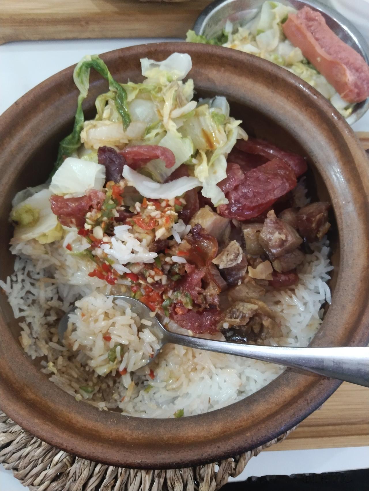 友友们看看这份腊味煲仔饭，看着是不是很有食欲？砂锅里米饭粒粒分明，铺上油润的腊肠