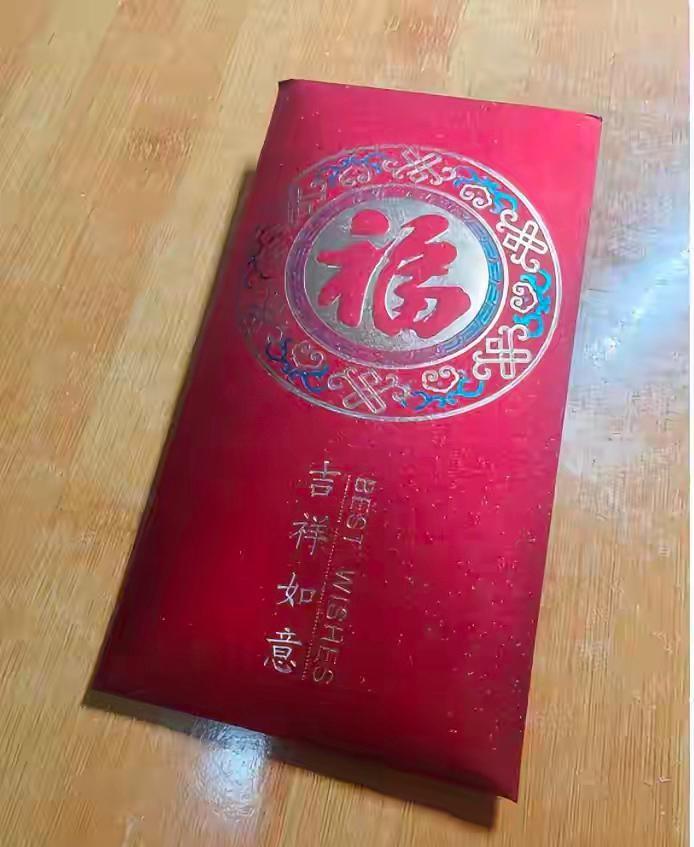 表弟结婚，我请假回老家，按这边行情包了一千，封在红底烫金的福字红包里，写名字还核