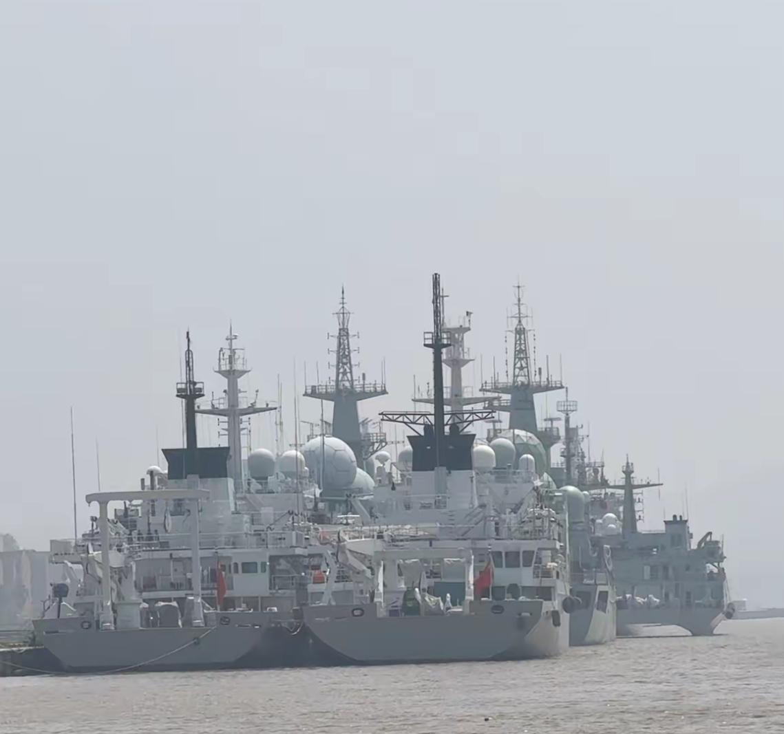 某军港内一堆的军舰，看上去阵容豪华强大。后排紧挨着停靠的两艘军舰应该是海上“街溜