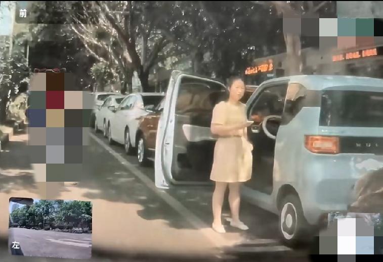 女子把车停在路边停车位上，开门直接堵住车道入口。后面的车要进去，鸣笛提醒后，她却