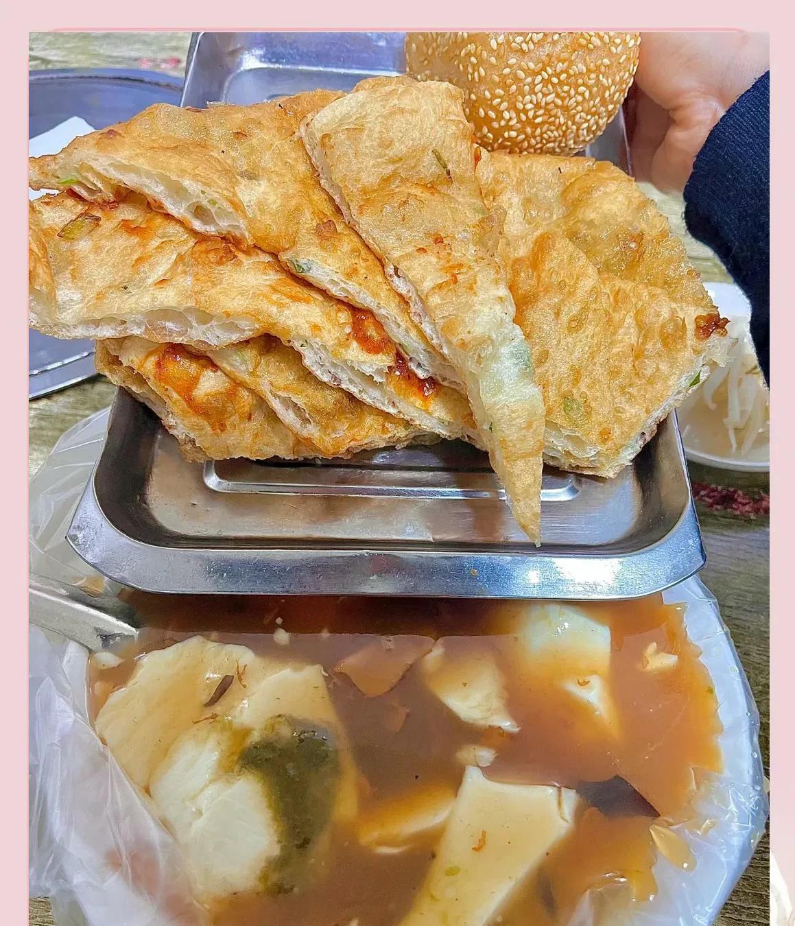 早上，某人说，有一家店豆腐脑做得特别地道，想载我一起去尝尝。出门时，看他拎着两