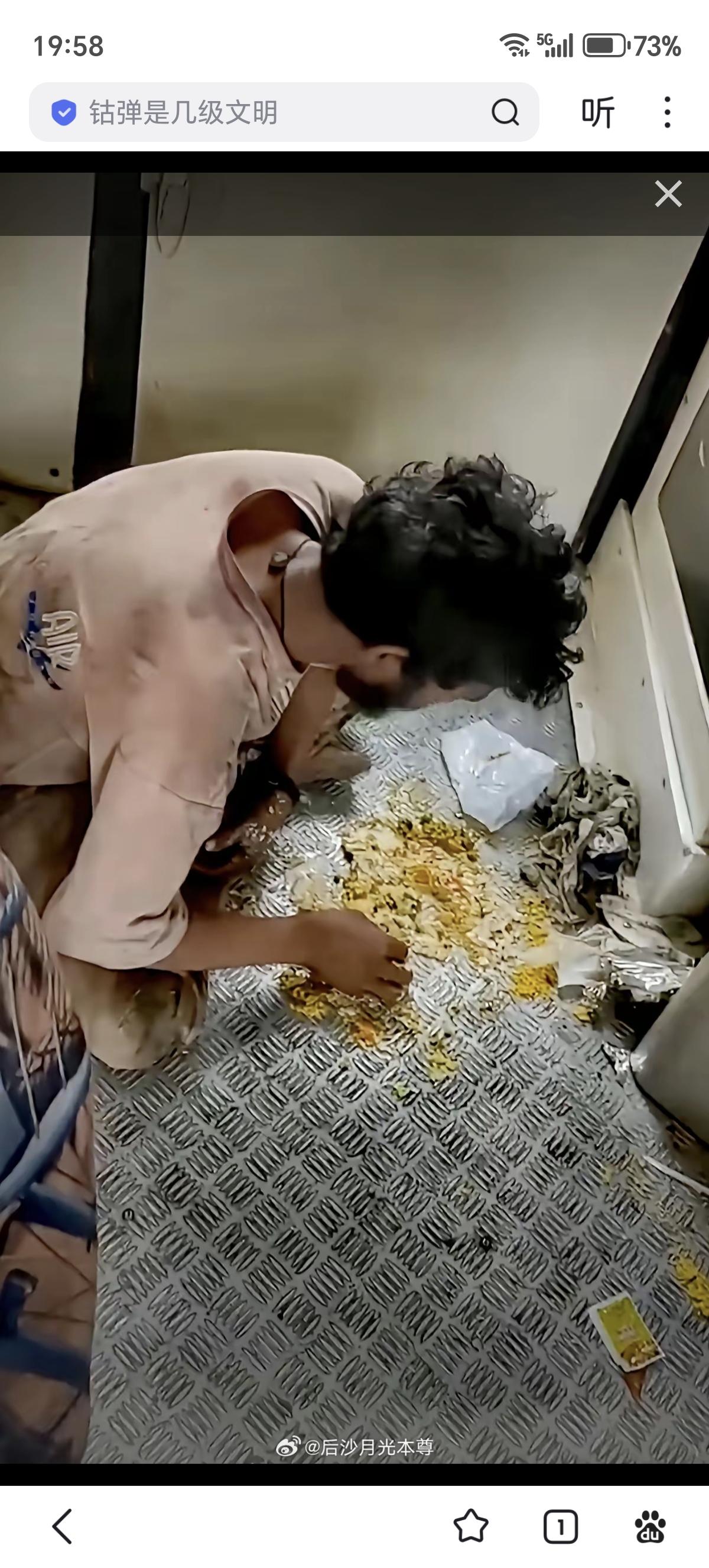 午饭时间，一名印度男人蹲在印度一列火车车厢连接处，把咖喱调料与米饭在防滑钢板上拌