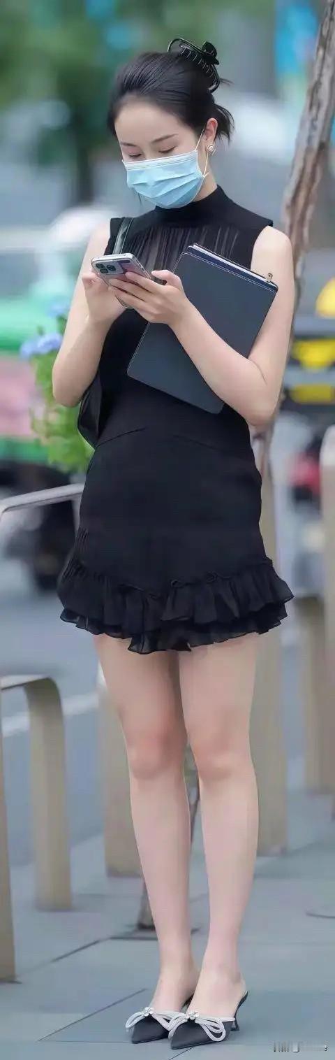 穿黑色裙子的女孩在打电话。