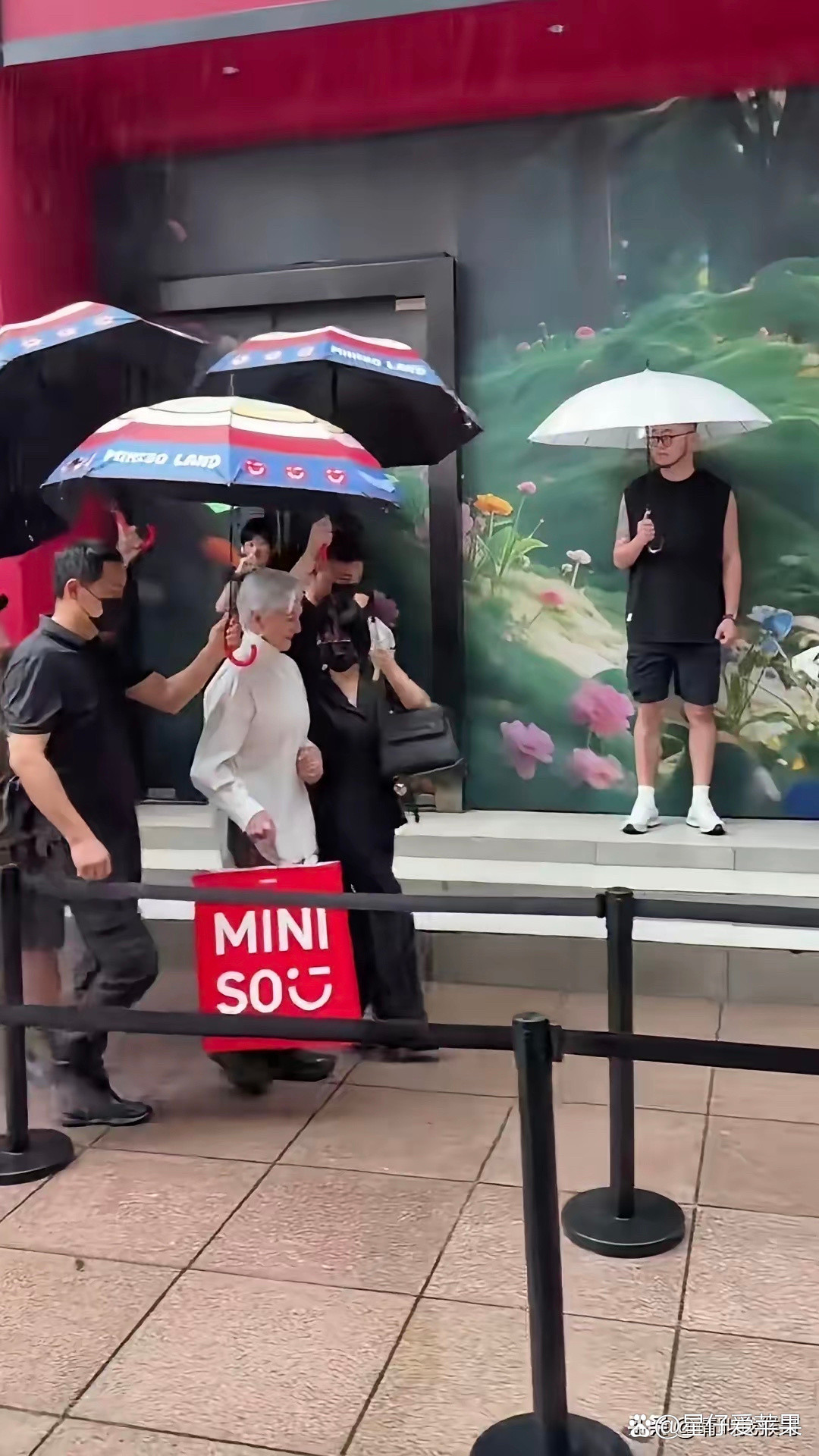 马斯克母亲上海逛街遇下雨，旁人围着撑伞，场面看着多少有点违和