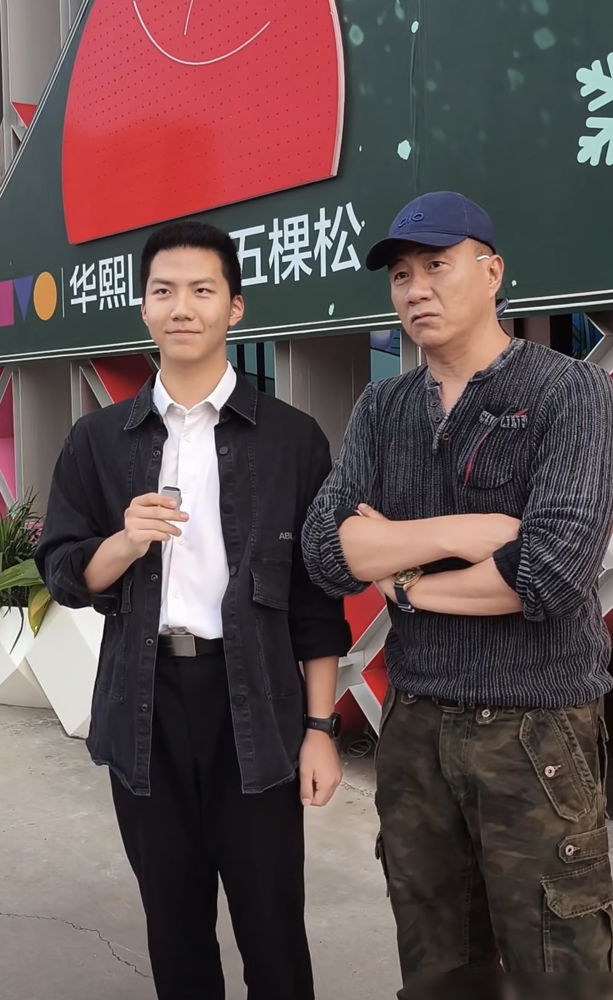 胡军一家四口往那一站，评论区直接炸了。17岁康康黑衬衫黑西裤，个头已经压过胡军，25岁女儿九儿大波点
