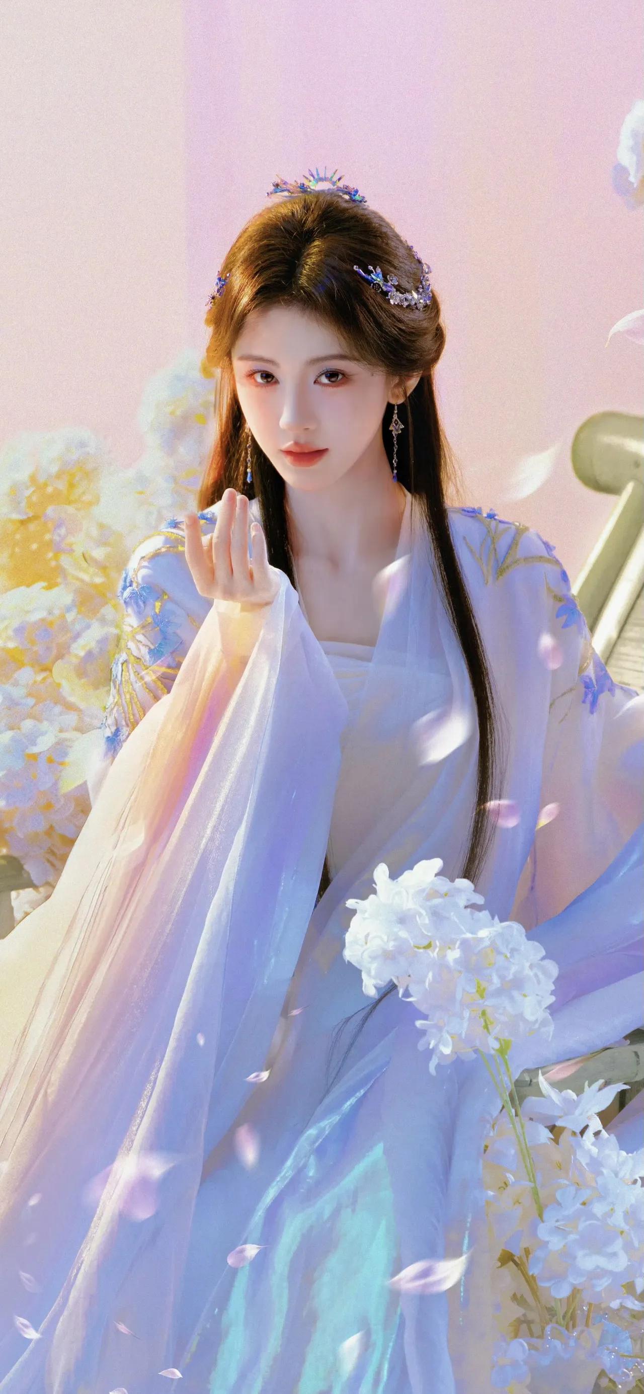 美女壁纸～鞠婧祎，淡蓝纱衣似流云漫过肩头，蓝蝶绣纹在衣间轻舞，团扇轻摇，花影绕身