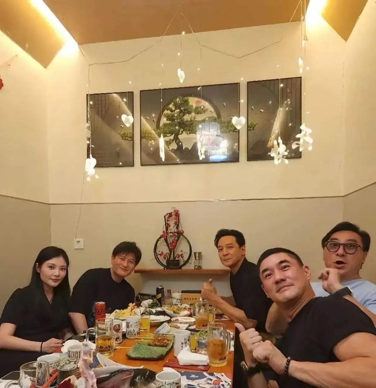 图中几位看起来气场不凡的人物相聚一堂，桌上摆满了丰盛的菜肴，各类杯盏交错。好奇他