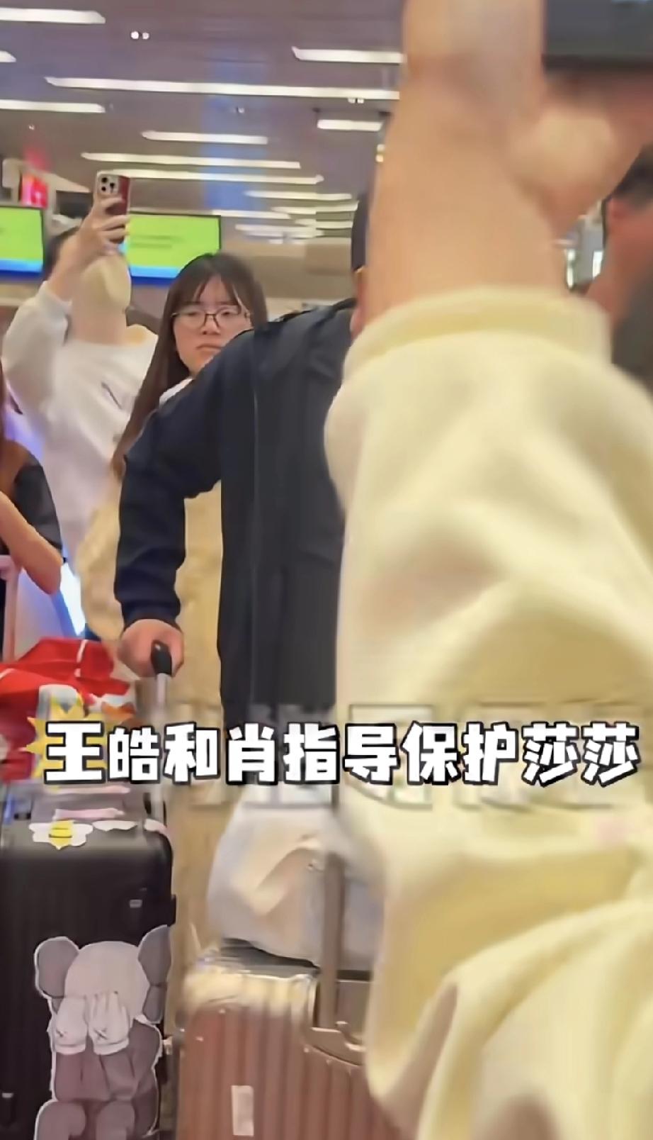 王皓和肖指俩人在机场保护莎莎。现场王皓指导一边推着行李箱一边眼神谨慎，感觉比指