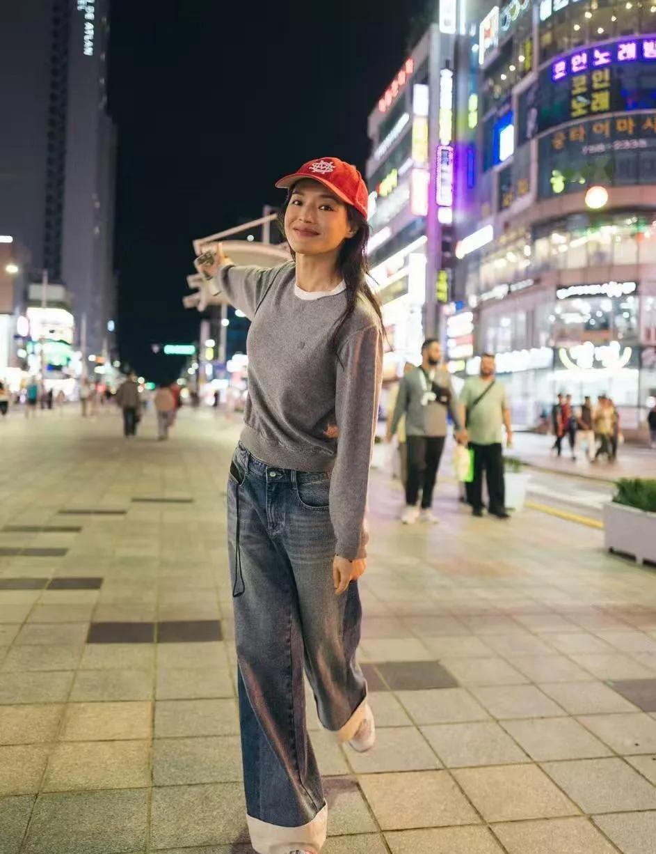 舒淇的冻龄松弛感赢麻了✨灰色针织衫+翻边牛仔裤+红帽，随性又减龄，笑容甜得