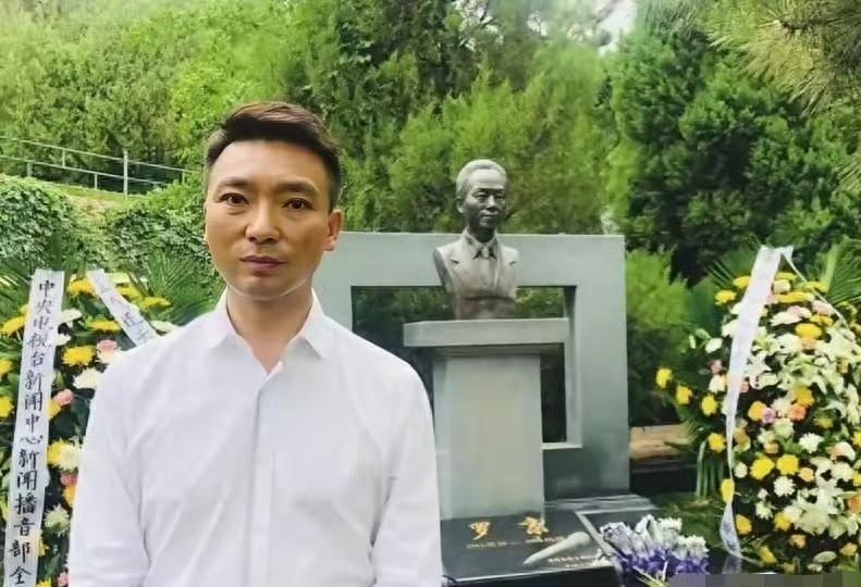 康辉给罗京扫墓，一张罕见的留影，拍摄于多年前，站在墓碑前，他神情肃穆。罗京