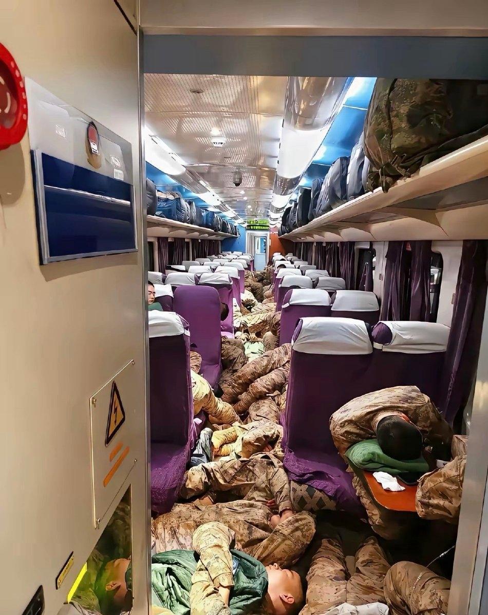 扎心！高铁车厢里这一幕谁看了不心疼？解放军战士们裹着迷彩，在过道里挤着、蜷着