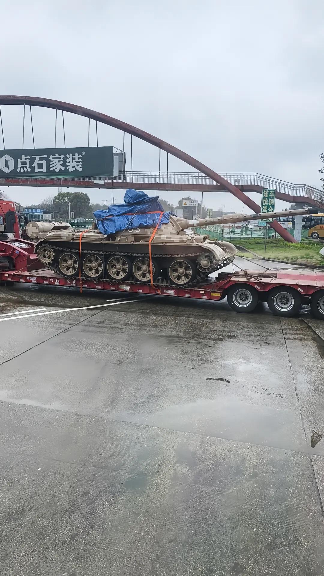 罕见涂装的某新型坦克，在国际庄某地使用平板车进行运输。经典五对轮的行走机构，中部