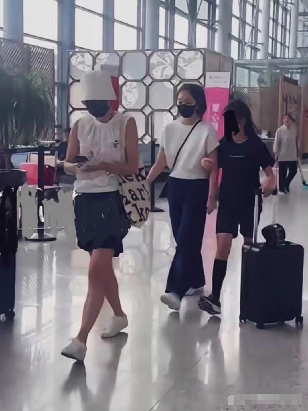 马伊琍母女三人现身机场，马伊琍戴着白色渔夫帽，黑色口罩全副武装，身材苗条，短衣短