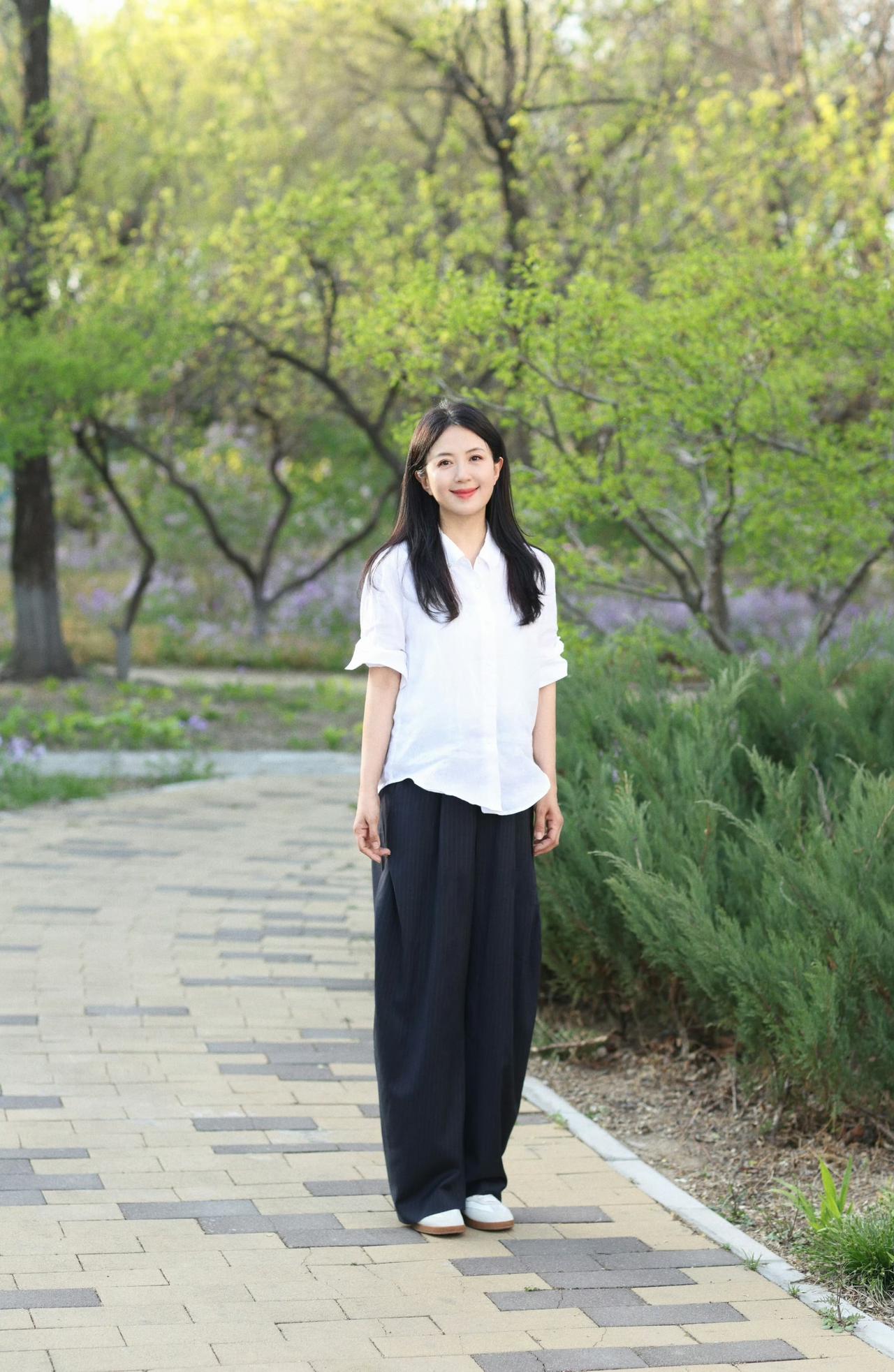 春日生活打卡季一身简单白衬衫，漫步在满是绿意的林间小径。阳光温柔洒落，草木清香漫