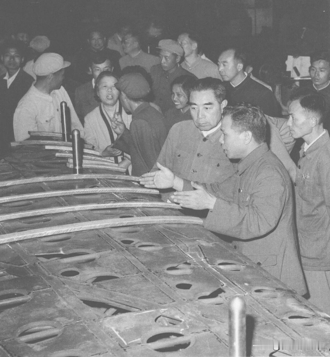 1962年6月13日，周恩来、邓颖超冒雨参观松陵机械厂（飞机厂），询问工人王传康