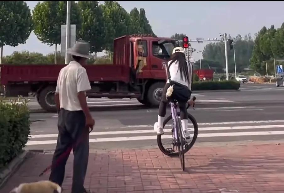 近日，一段骑车美女等红灯时不下车，看呆了一位遛狗大爷的视频在网上走红！一开始，