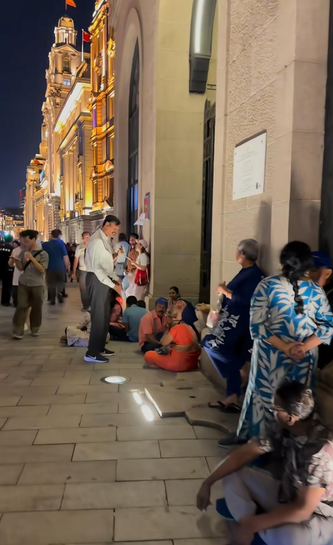 夜已深，外滩那些印度人，久久不愿离开，有些人索性席地而坐，也不愿意走进附近的店里