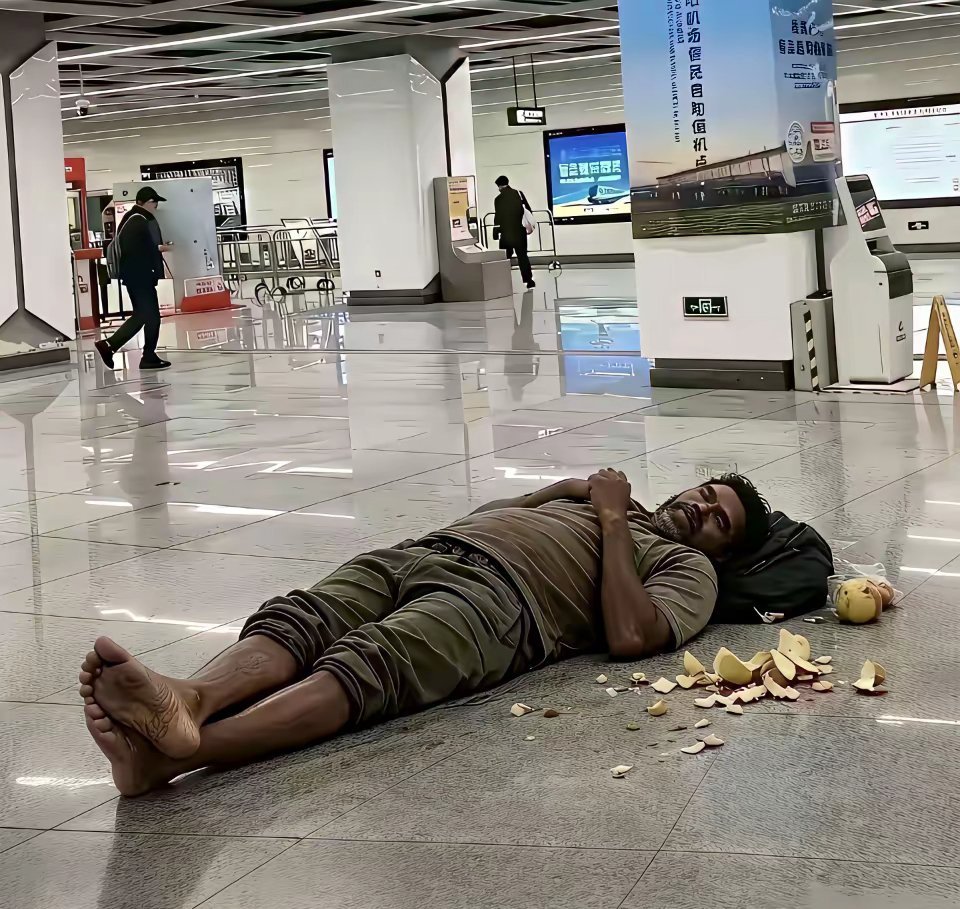 这位印度旅客累了，直接在机场地板上蜷着睡了。反正有空调挺凉快，去酒店还得花钱，出