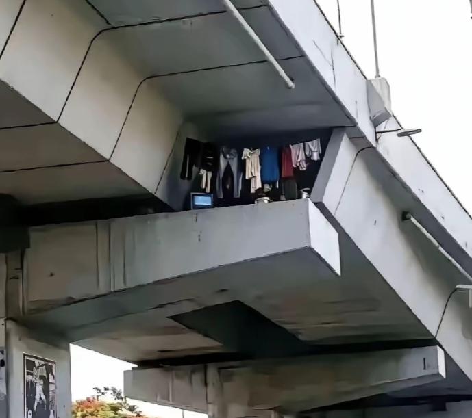 重庆，一男子乘01路公交经过一个高架时，无意看见桥梁狭窄缝隙里竟晾满了衣服，电脑