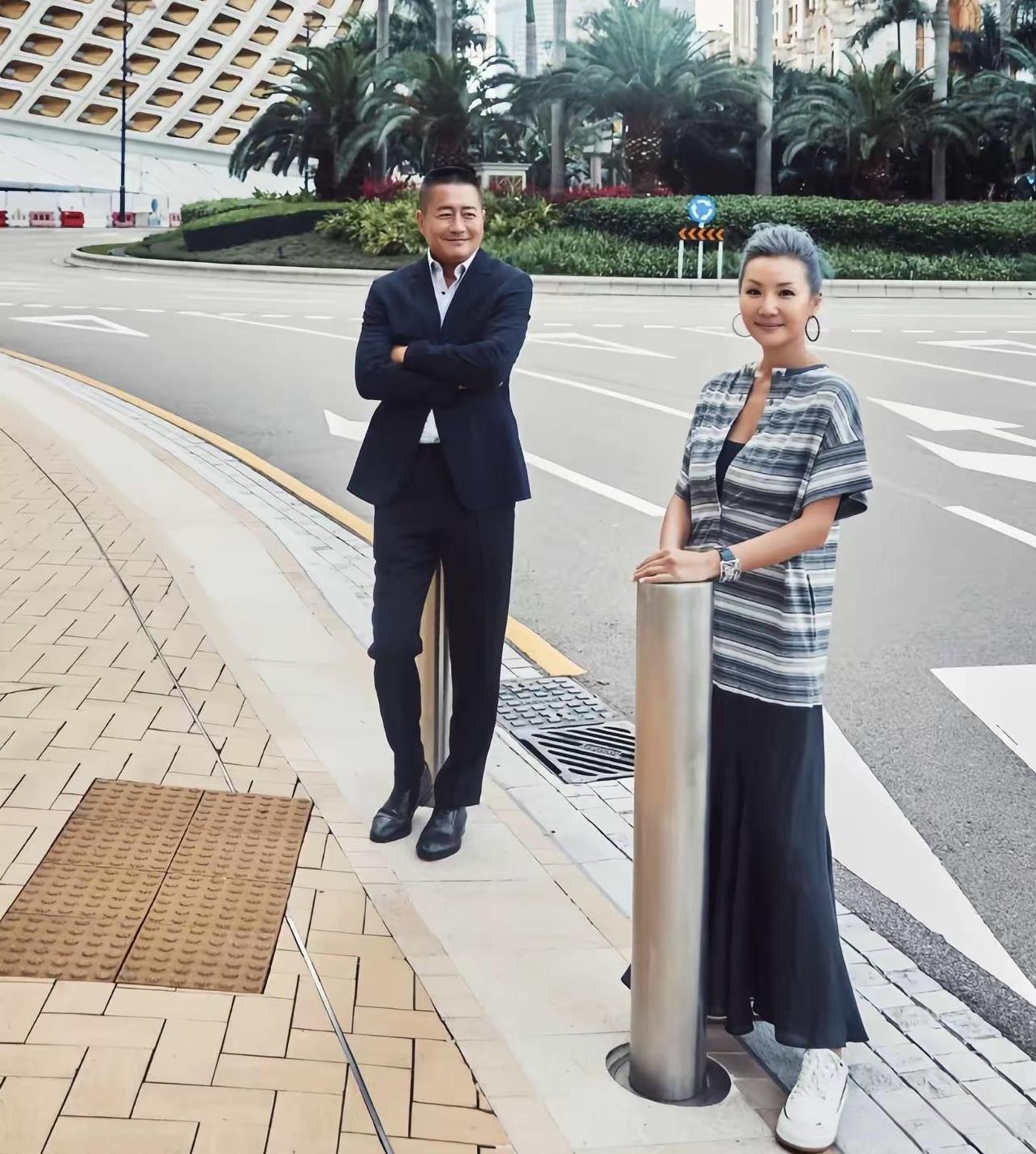 这是高曙光与夫人的合影照，两人分别靠着一根柱子，但高曙光的眼睛始终看着夫人，面带