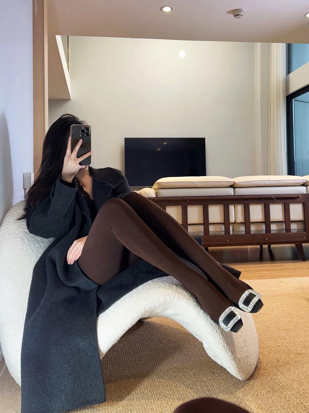 深棕连裤袜是今天的主角。细腻的哑光面料顺着腿型延伸，把小腿线条修饰得流畅又温柔