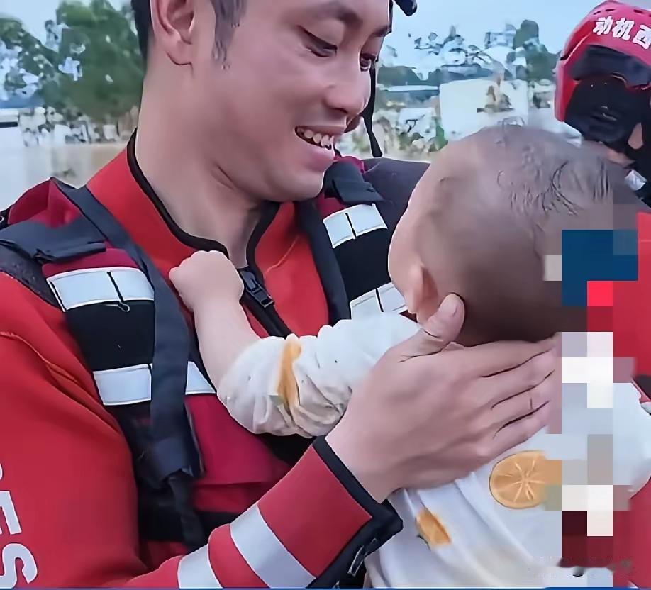 近日，广西南宁，一名救援人员怀抱一名婴儿，只见他一手抱着宝宝，另一只手托着宝宝后